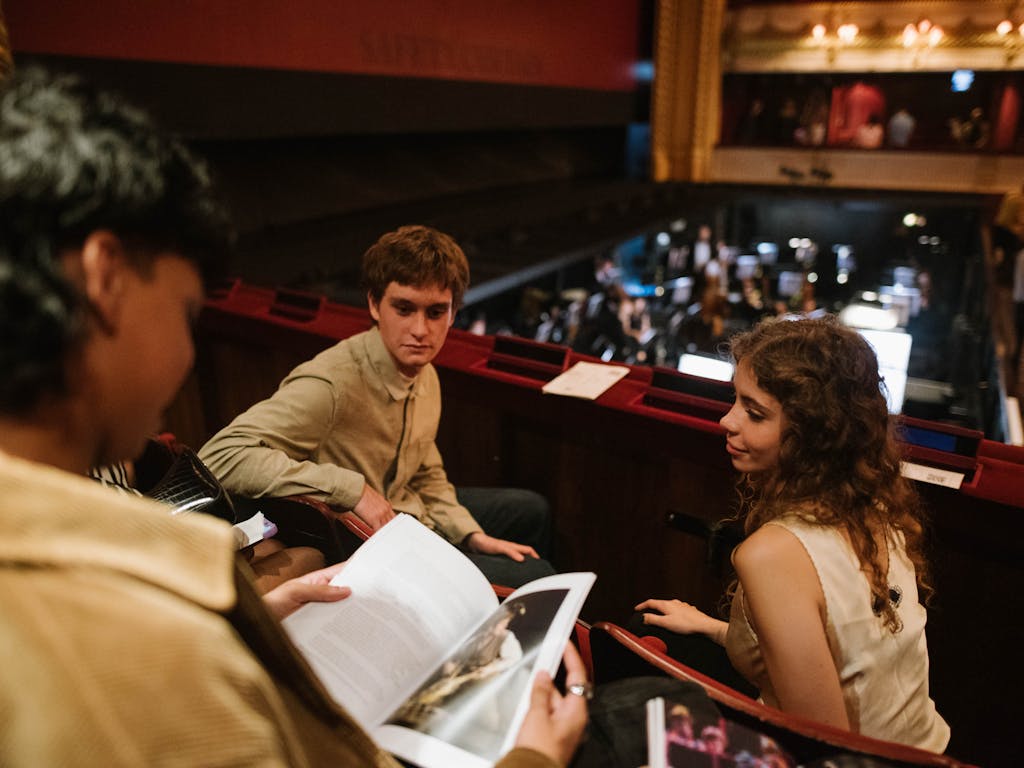 Two audience members sitting in the main auditorium of the Royal Opera House.