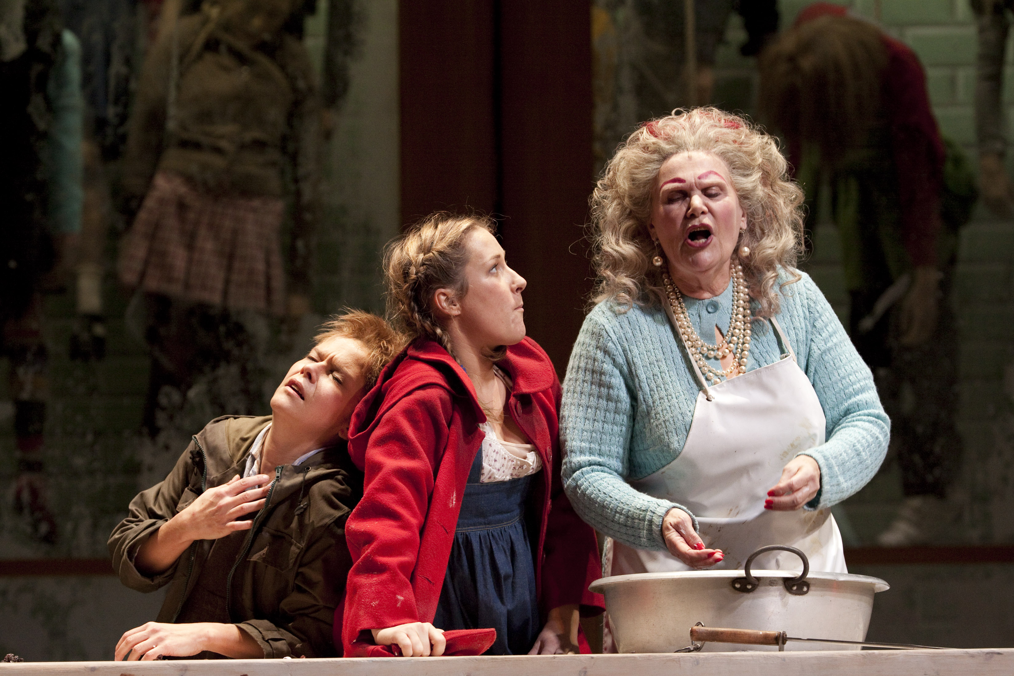 A boy and girl annoy their mother who is cooking