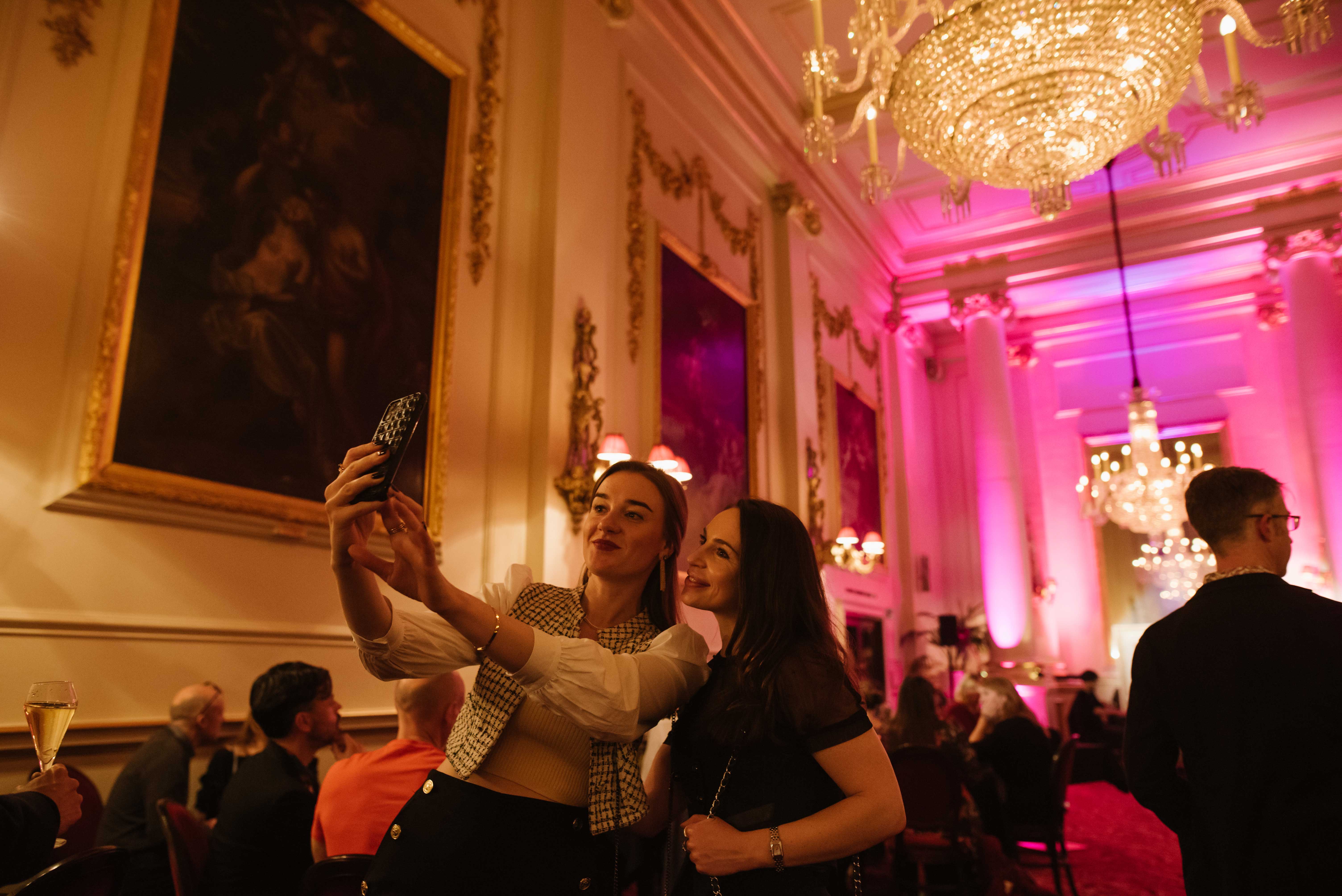 Two women taking a selfie in the Crush Room at the Royal Opera House.