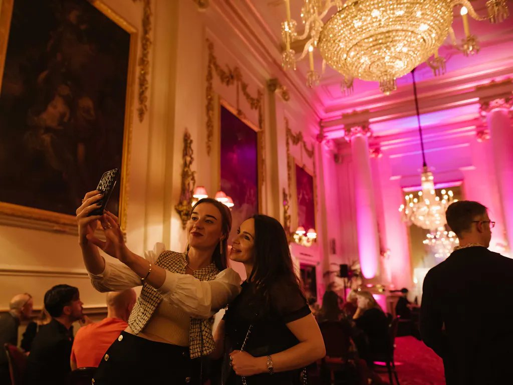 Two women taking a selfie in the Crush Room at the Royal Opera House.