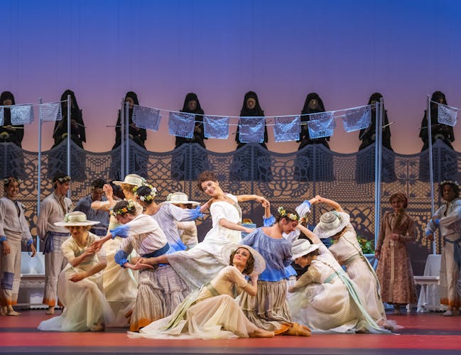 A group of ballet dancers performing together during a show at the Royal Opera House.