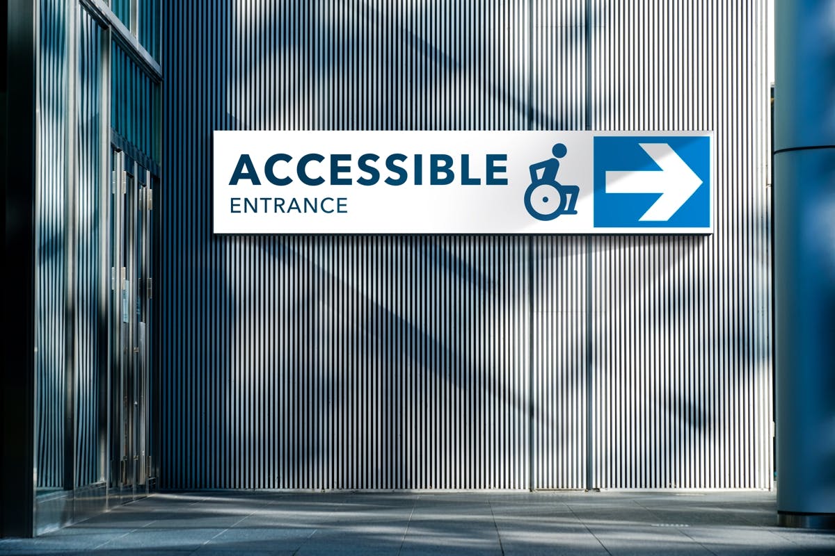 Sign with wheelchair graphic and right-pointing arrow. Text reads 'Accessible entrance'.