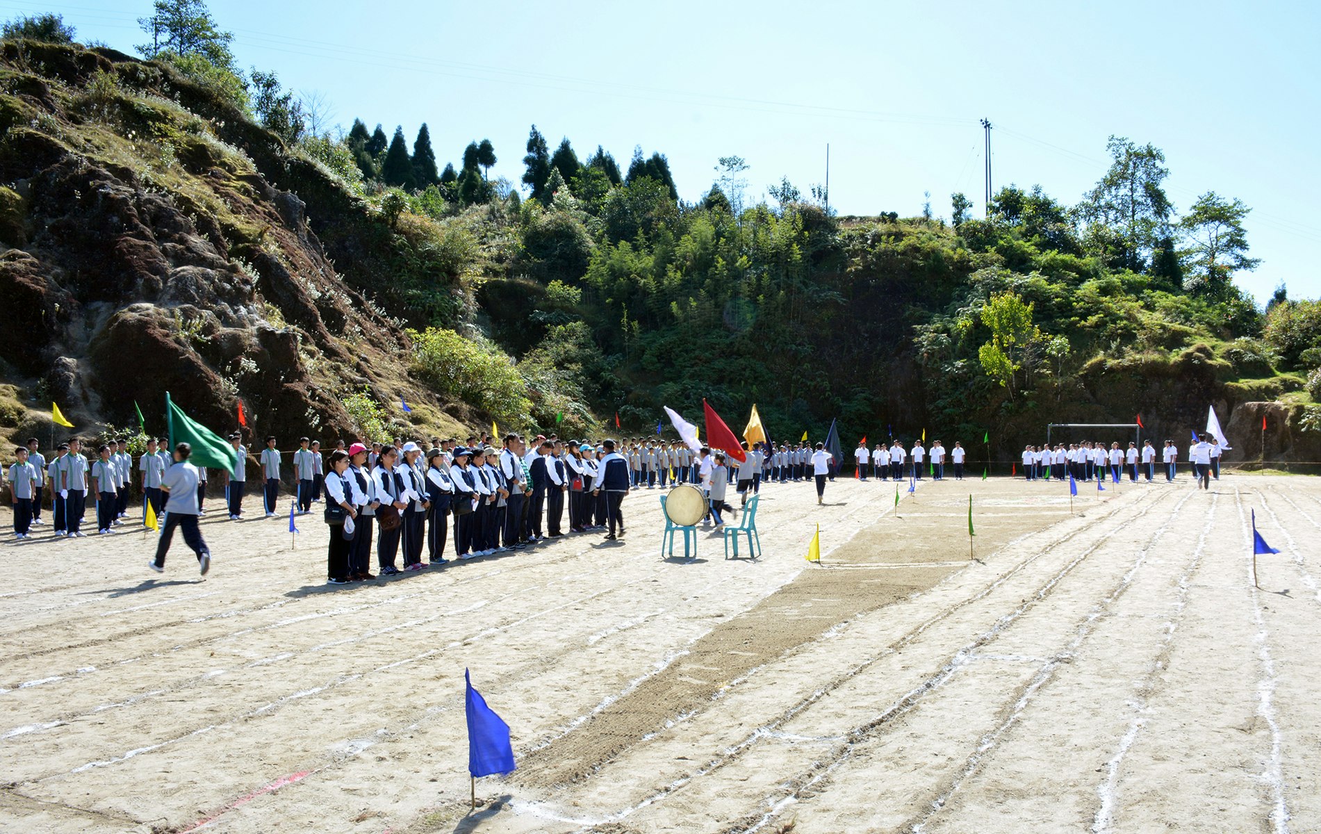 Unifying Strength: Teachers and students come together, forming a united front on Sports Day, with the picturesque backdrop of nature's beauty. A vibrant display of teamwork, camaraderie, and school spirit.