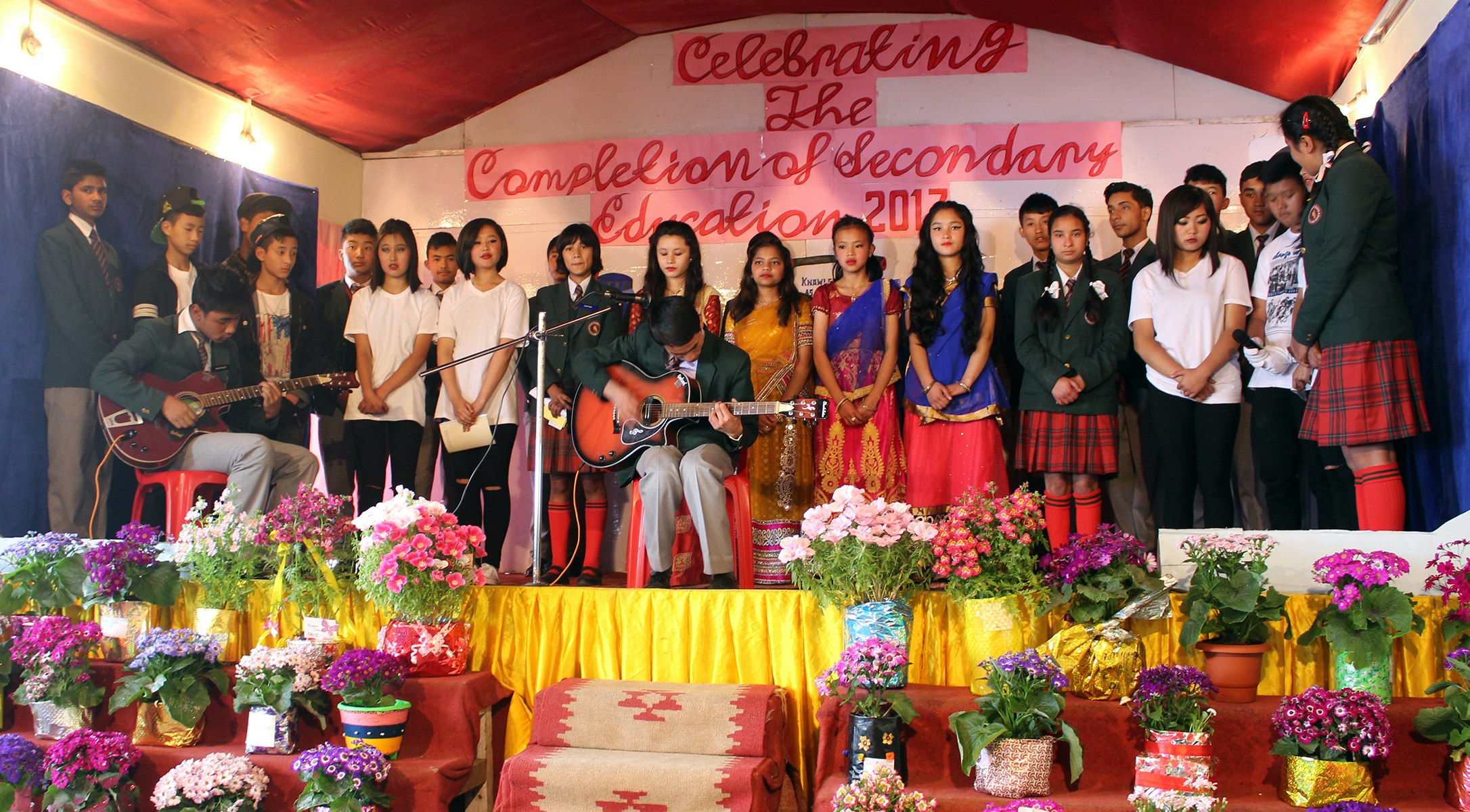 Melodies of Achievement: Students rejoice and create lasting memories as they celebrate the completion of their secondary education through heartfelt music and harmonious melodies on the grand stage.