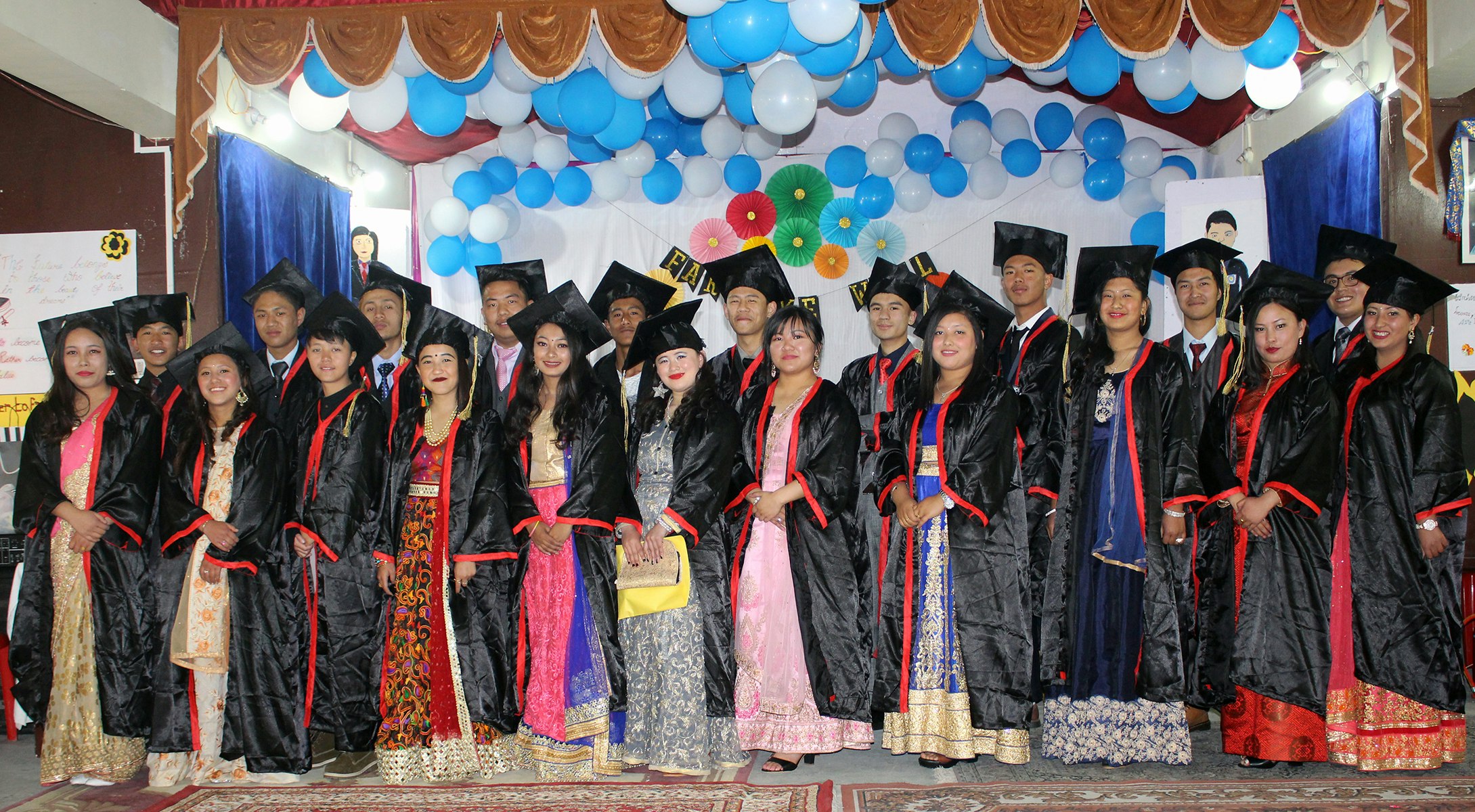 Stepping into the future with pride and accomplishment. Our graduating students gather on the stage, adorned in their distinguished attire, as they celebrate the culmination of their academic journey. Surrounded by vibrant blue and white balloons, their spirits soar high, ready to embark on new adventures. Congratulations, graduates, on this momentous milestone!