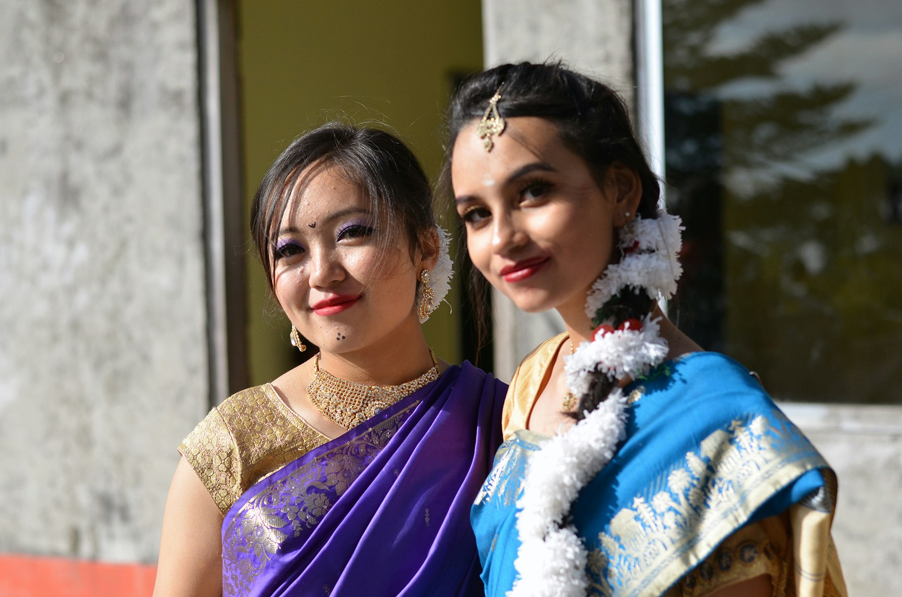 Graceful Traditions, Timeless Elegance: Two high school girls donning traditional saree dresses, adding a touch of splendour to the auspicious day, against the backdrop of our beloved school.