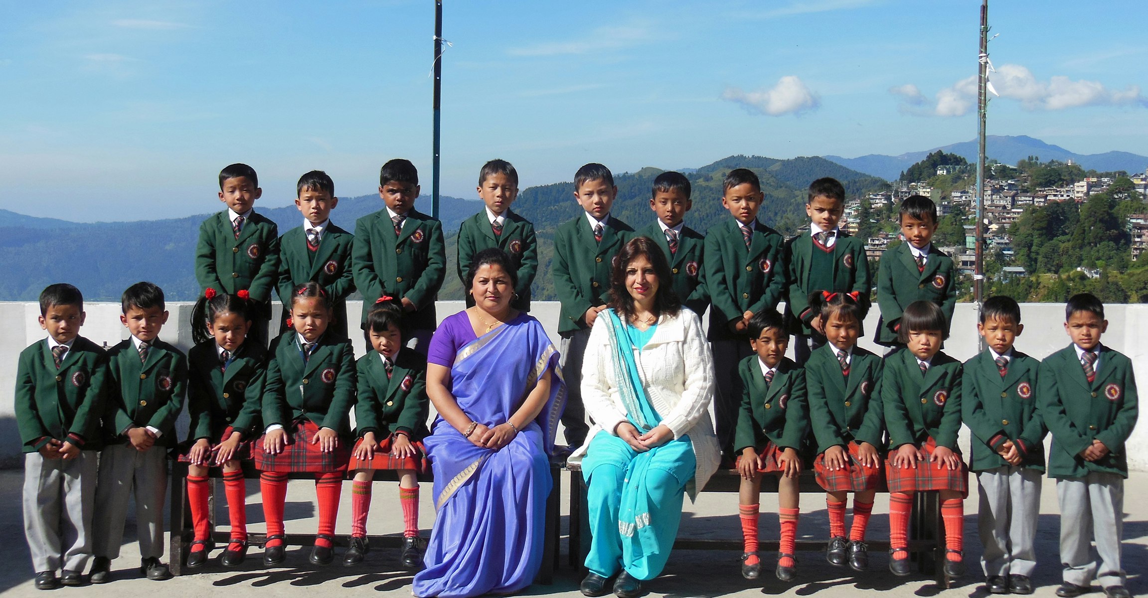 Bright Smiles, Bright Futures: Our junior school students, accompanied by their teacher and our esteemed principal, bask in the warmth of a sunny day at our school. With the picturesque mountains and the enchanting towns of Ghoom and Jorebunglow as their backdrop, they embark on a journey of knowledge and discovery.