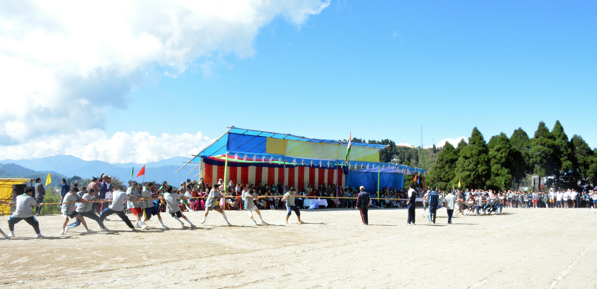 Strength in Unity: Students embrace the spirit of competition and teamwork as they engage in an exhilarating tug of war on a sunny sports day, surrounded by the majestic mountains.