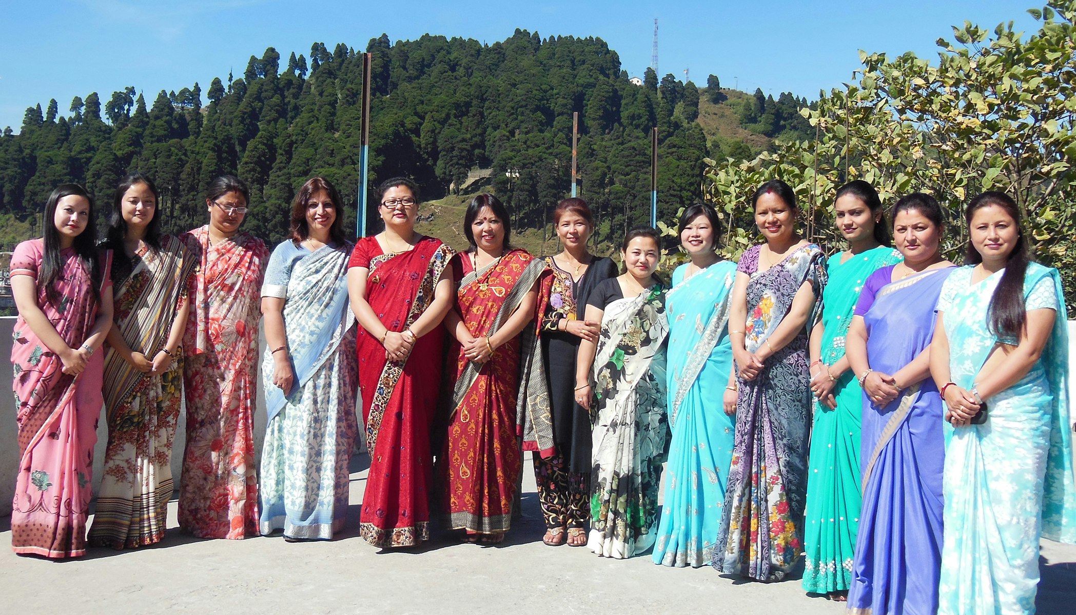 Radiant Elegance: Our lady teachers donning vibrant traditional saris, bring a splash of colour to the school grounds. Against the backdrop of the majestic Jalapahar ridge adorned with lush green trees, they embody grace and inspire with their dedication to education.