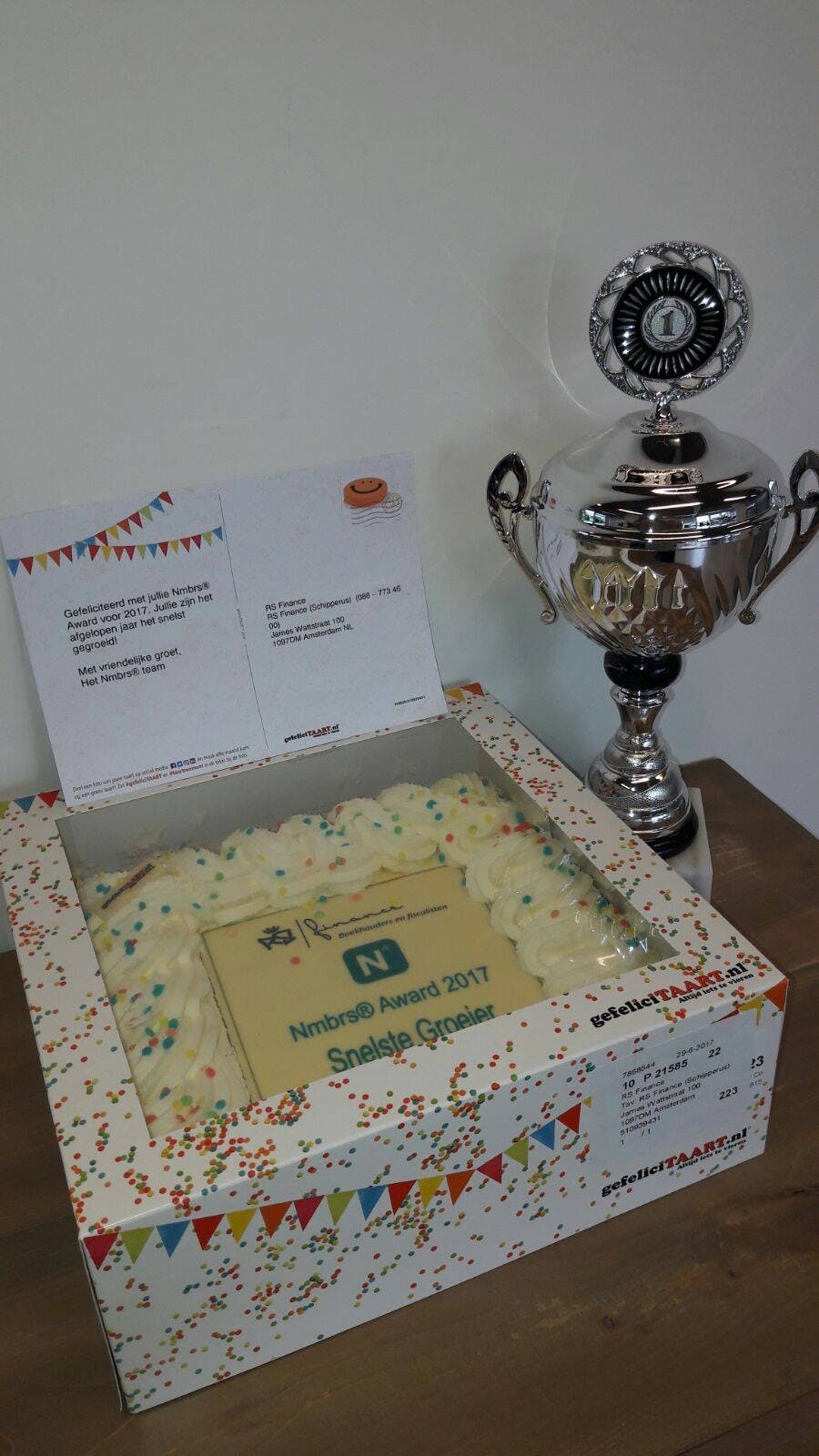 Een cadeau van Nmbrs: een kaart, slagroomtaart en een grote zilveren kampioensbeker