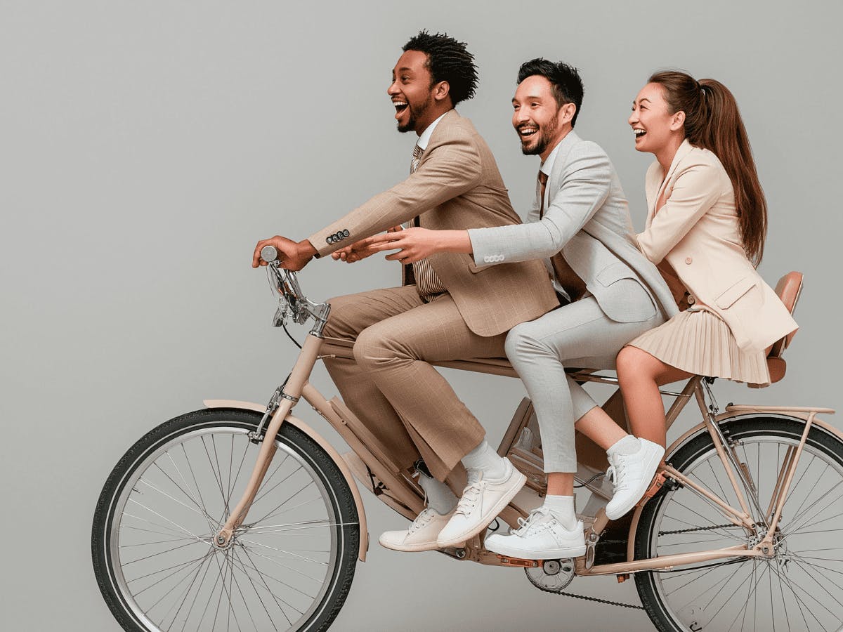 Drie zakenmensen rijden samen op een fiets (beeld gegenereerd door AI)