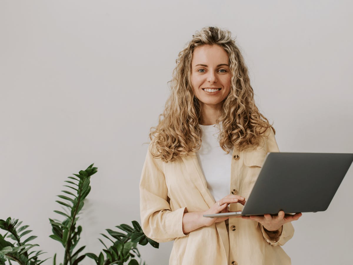 Jonge vrouw met een open laptop in haar handen