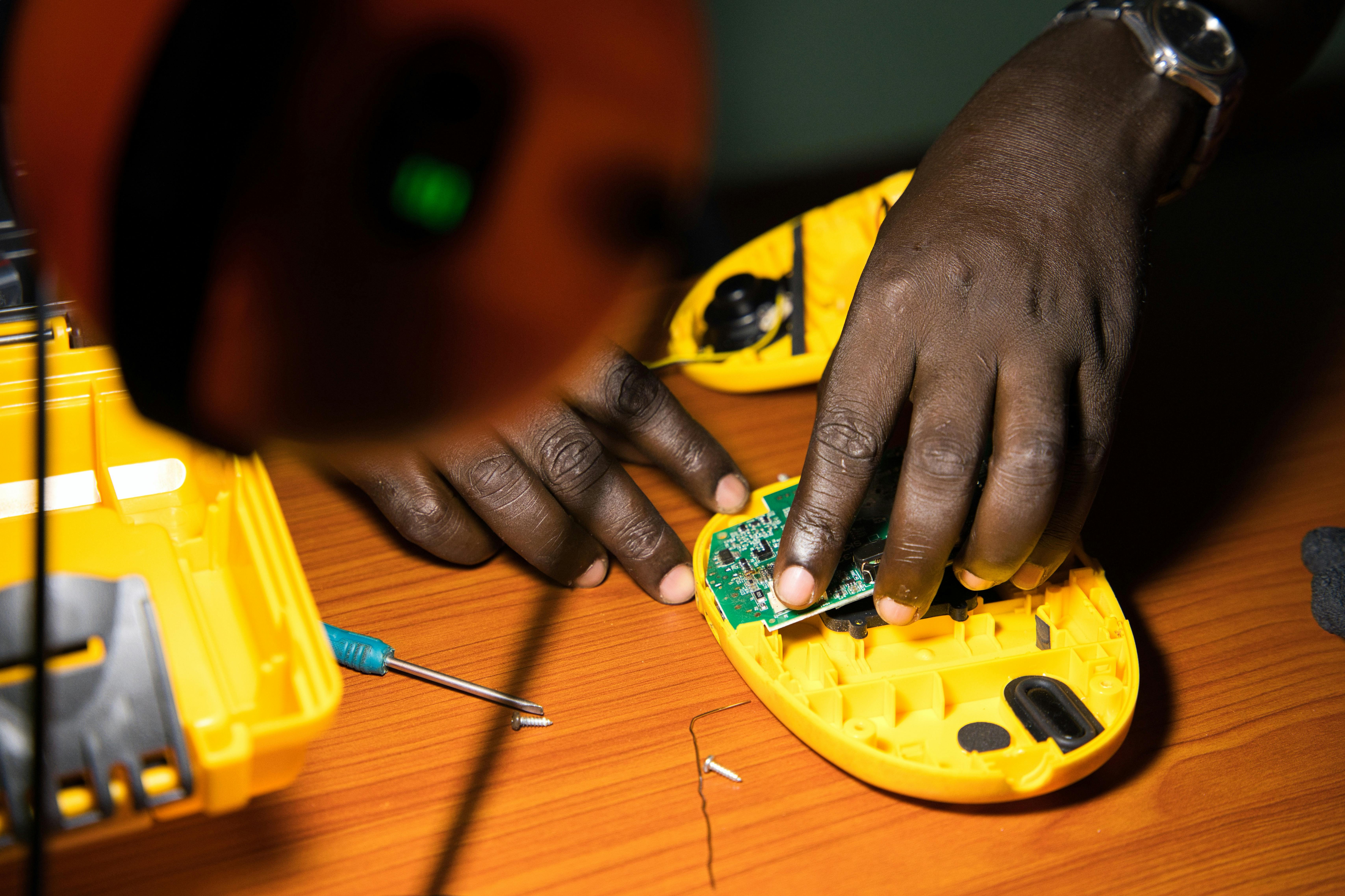 A person using their light to work on electronics.