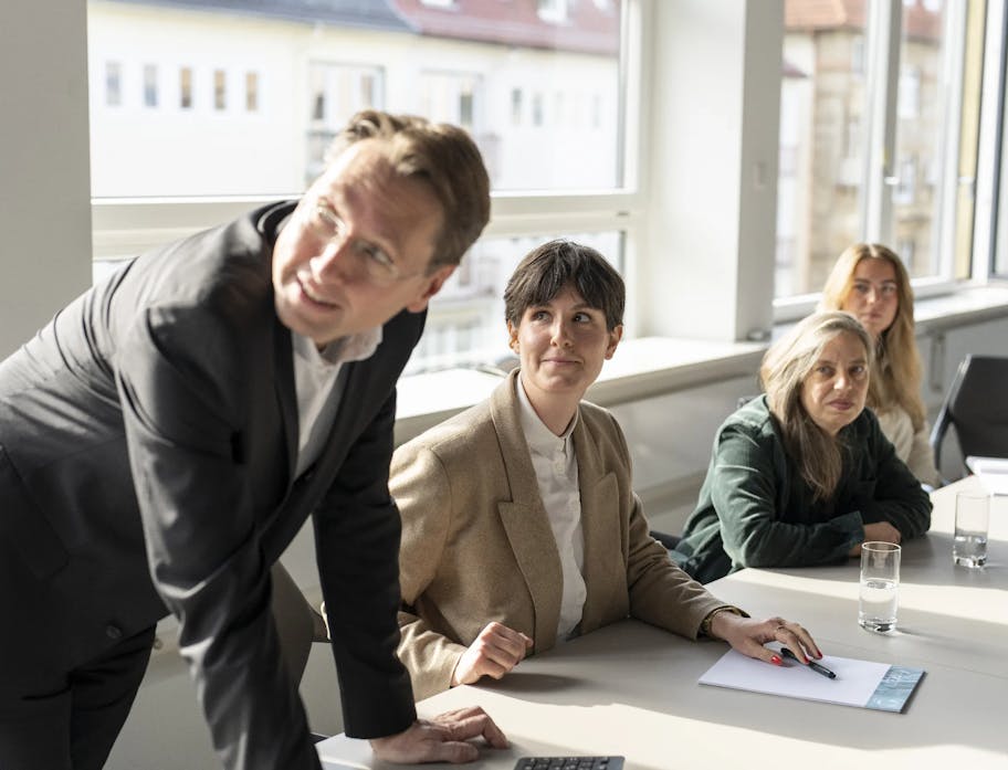 Employees of the b2b marketing agency Ruess Group sit at a meeting table