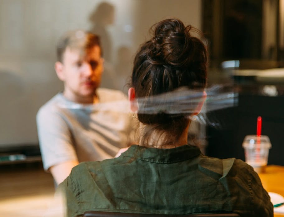 The image shows a woman and a man in conversation.