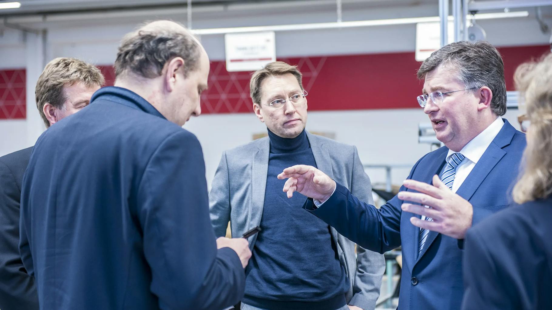 Geschäftsführer der Ruess-Group hört auf dem Pressetermin aufmerksam einem Vertreter von Interstuhl zu 