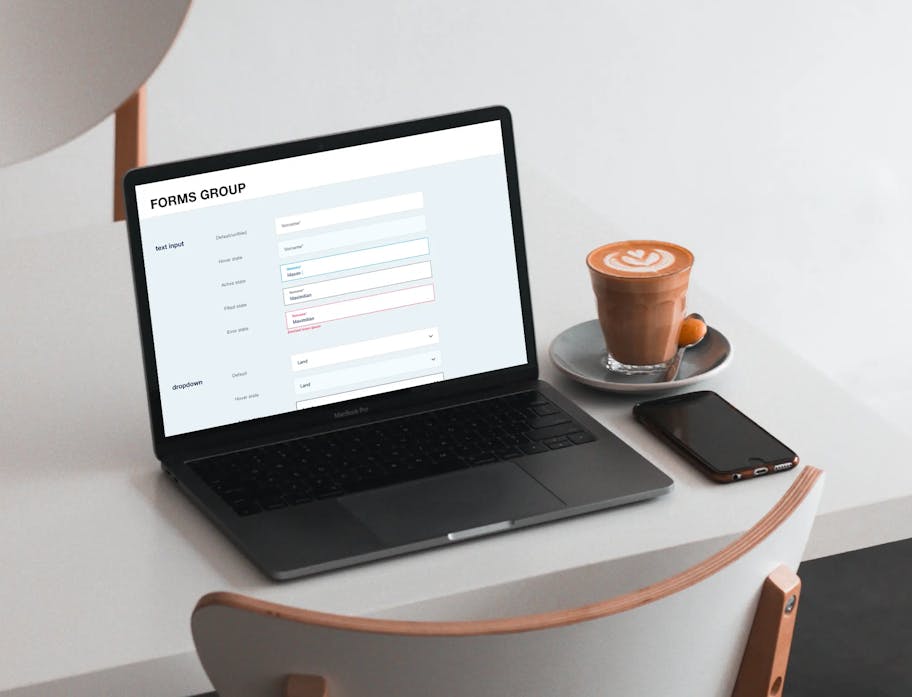 Nahaufnahme eines Laptops der den Bereich Foarms Group, im Programm Figma anzeigt und links neben einem Kaffee und einem Handy steht