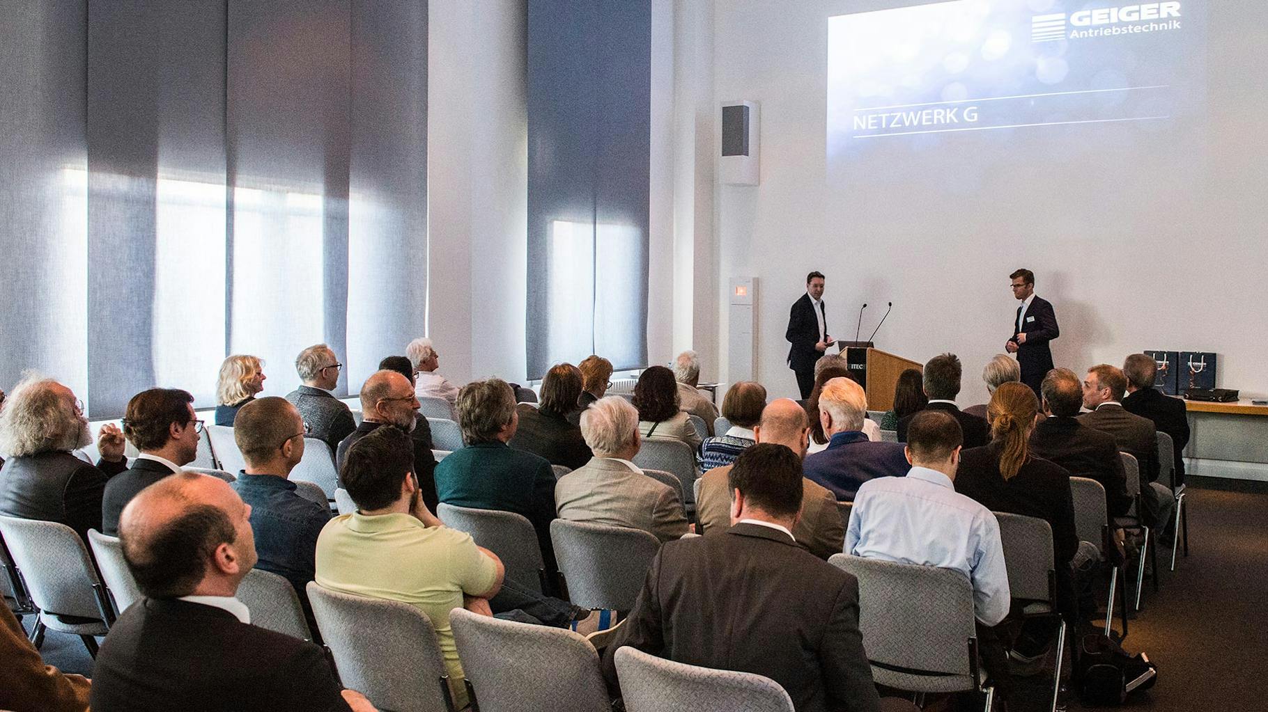 Die Gäste beim Geiger-Event hören bei einem Vortrag zu