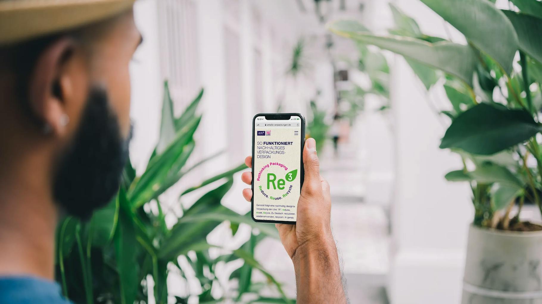 A man watching Antalis' Sustainability Microsite on his mobile phone