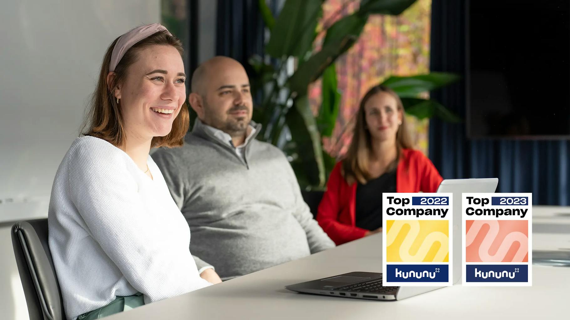 Three employees sit together at a table and talk about the sustainability strategy