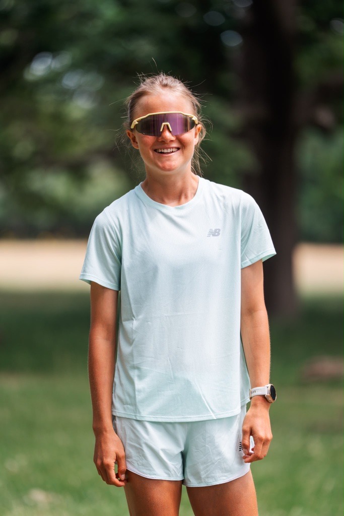 Ashleigh Harvie smiling at the camera wearing running gear and sunglasses.