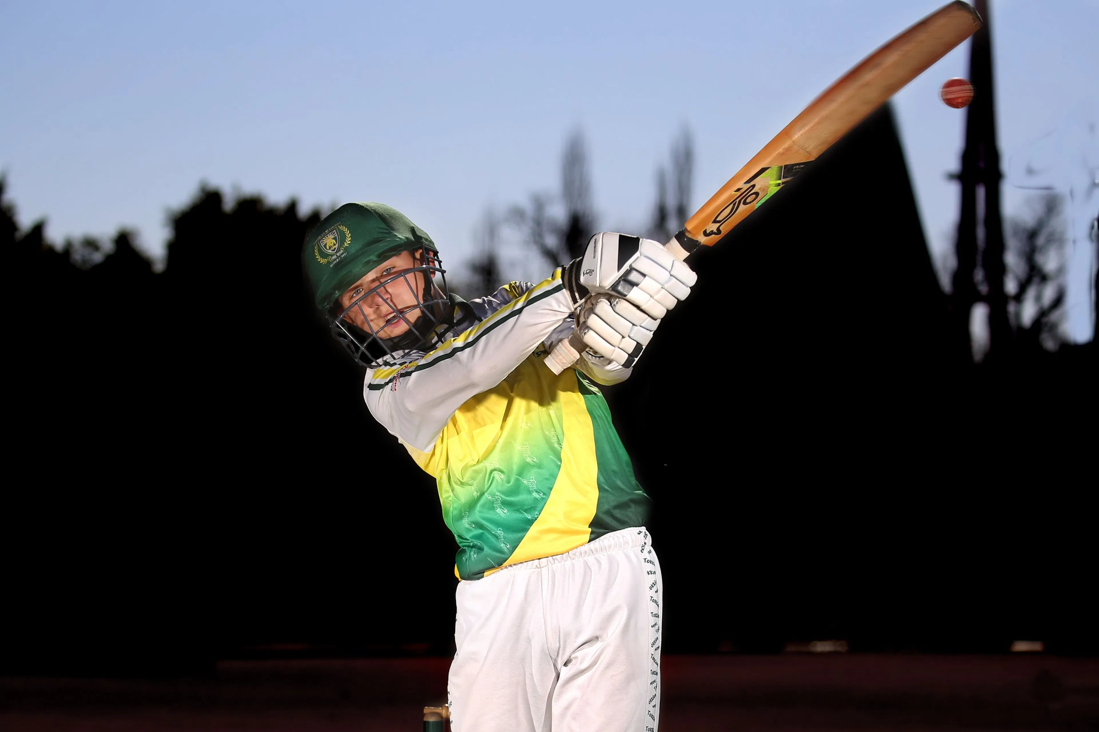 Cricket batsman swinging through a shot