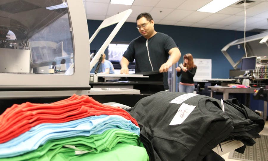 DTG printer and stacks of cotton T-shirts.