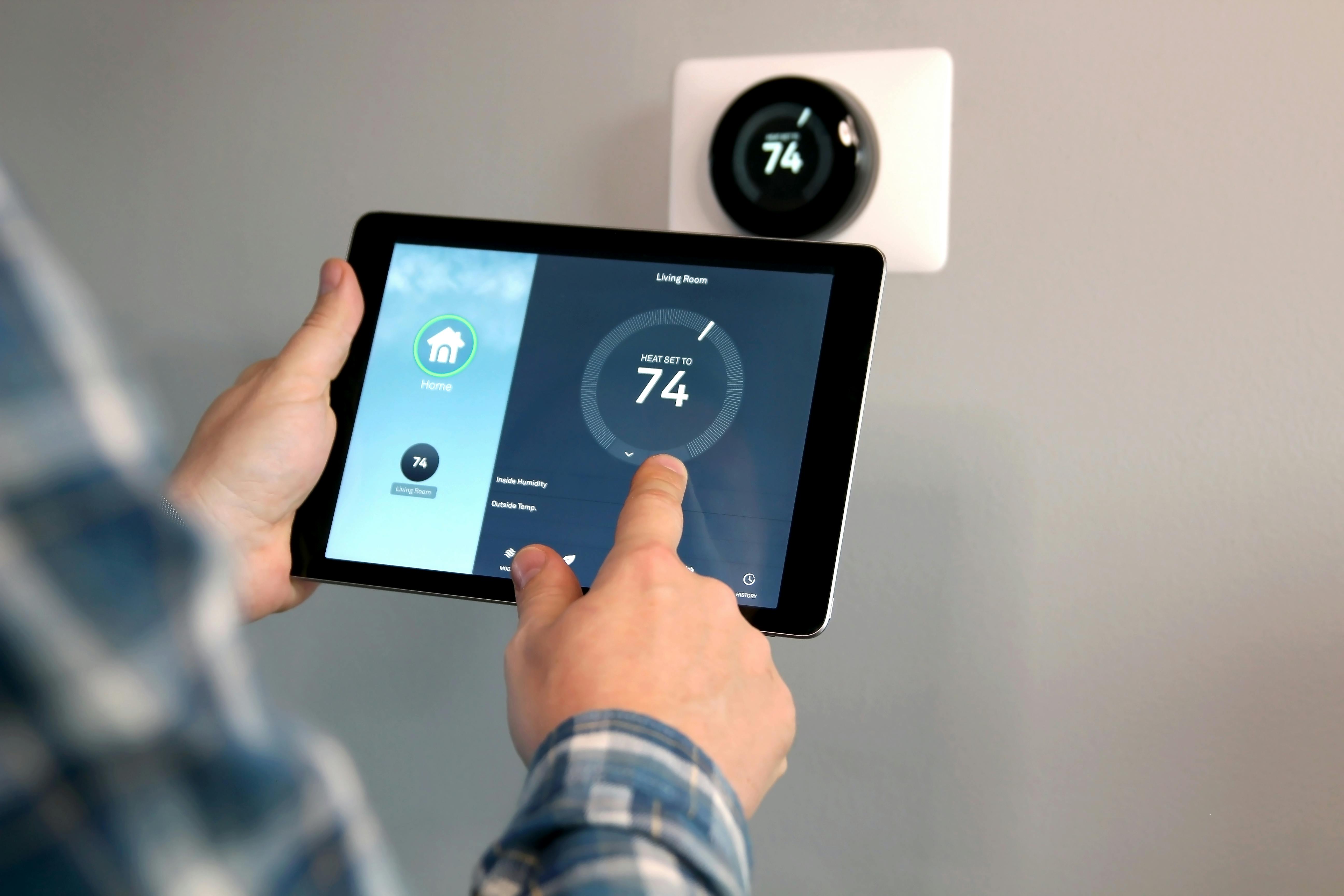 Man adjusting smart thermostat