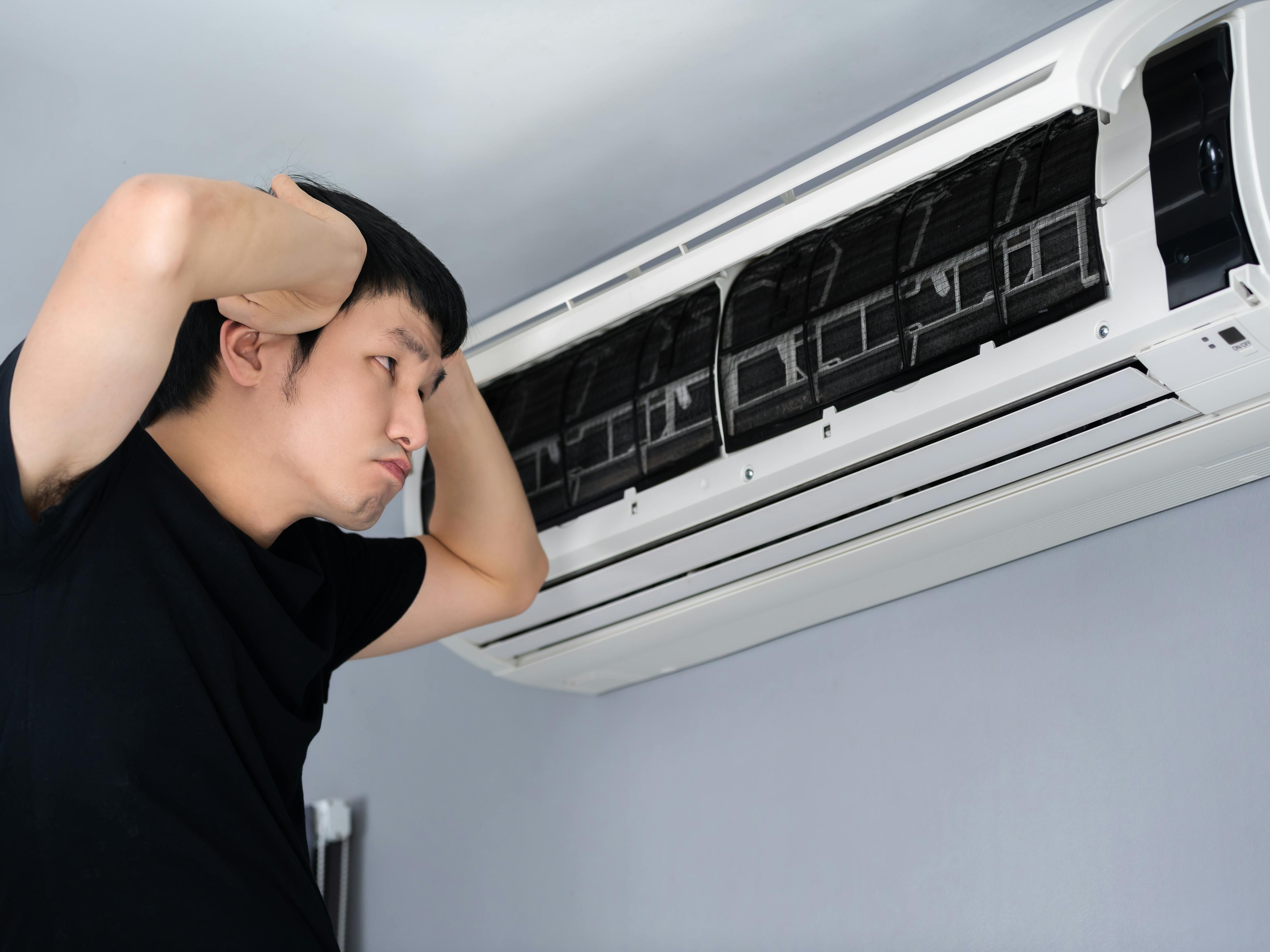 Stressed man has problem with the air conditioner at home