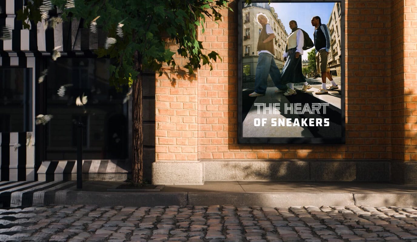 The scene shifts to a brick wall along a cobblestone street, where the same poster and trio appear, seamlessly blending streetwear culture with the city’s vibrant energy.