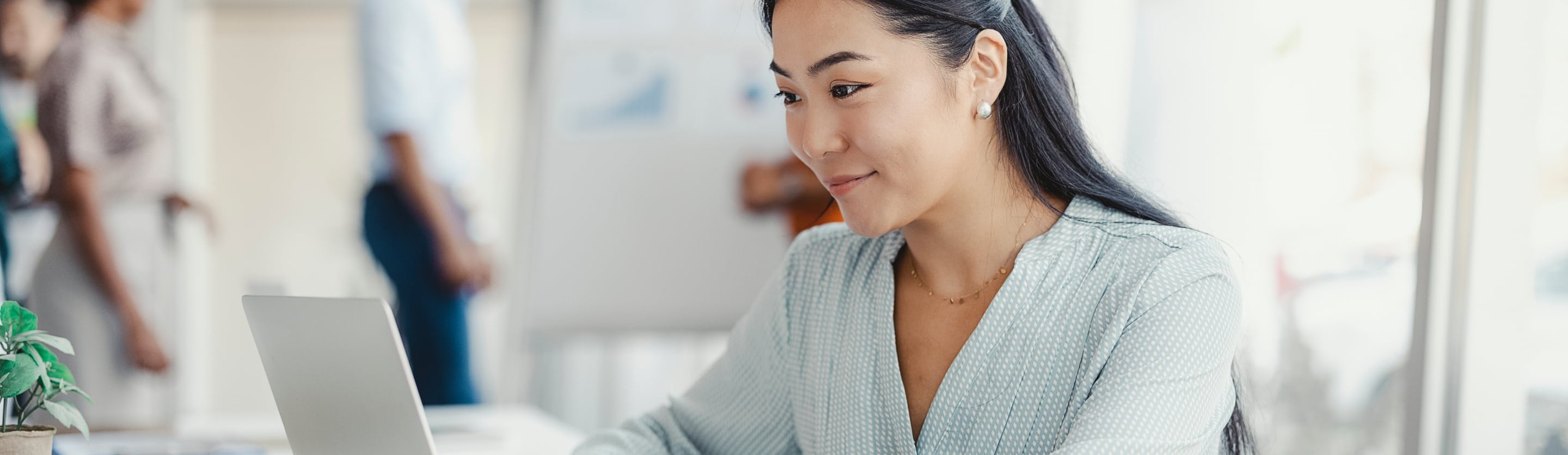 A smiling woman looks at her computer screen, representing her happiness and satisfaction with her work at s01ve Ltd.