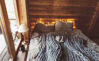 cottagecore themed bedroom with twinkling lights and cozy bed sheets