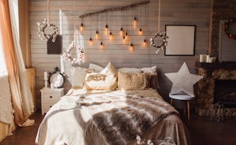 cozy bedroom with blankets, lights, and decor