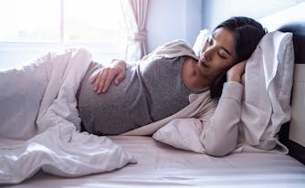 pregnant woman sleeping in bed
