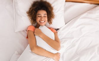 person hugging a weighted pillow