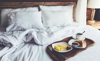breakfast in bed featuring eggs, toast, and coffee on a tray
