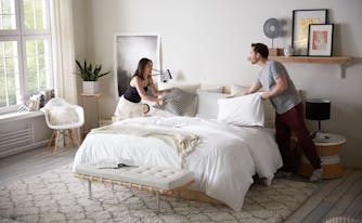 couple making bed together