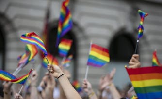people holding lgbtq rainbow flags