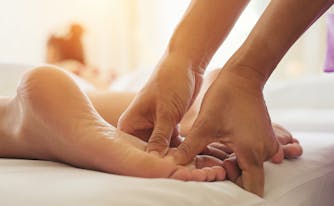 hands massaging foot during reflexology massage
