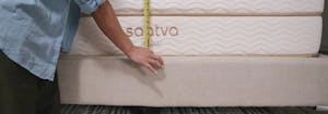 person measuring a mattress