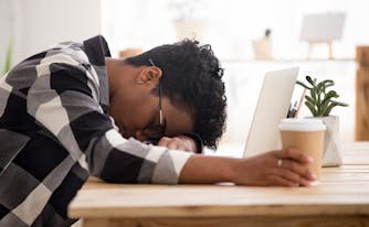 person with sleep disorder sleeping with head down on desk