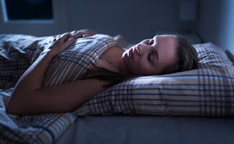 person sleeping in dark bedroom