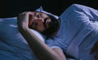 person with sleep paralysis staring in bed