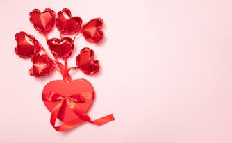 valentine's day heart shaped box with red heart shaped balloons