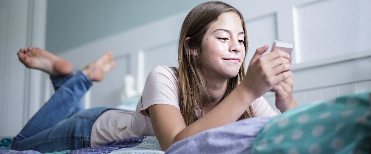tween looking at phone in bed