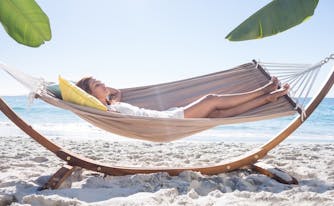person sleeping in hammock on beach