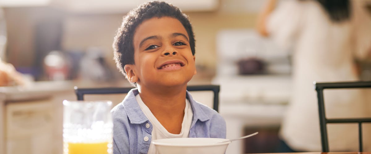 child eating breakfast before school in the morning