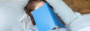 image of woman with book over her face - sleep learning