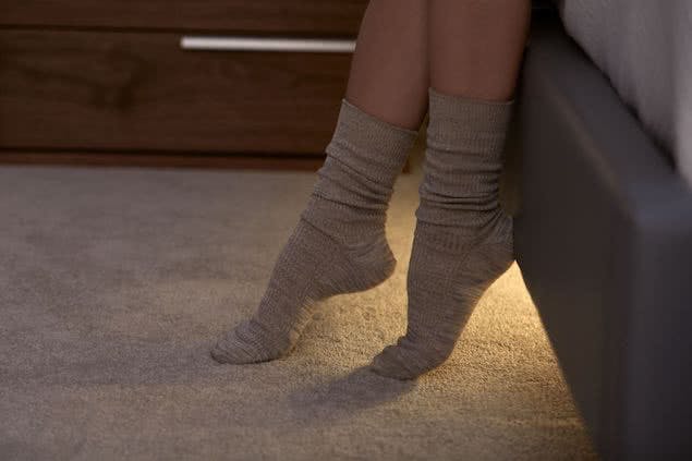 person's feet getting out of bed with lights underneath adjustable base