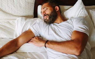 best sleeping position for back pain - image of man sleeping on back